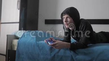 少年儿童和操纵杆男子网络运动帽衫吸收在网络电子游戏。 头罩里的少年男孩